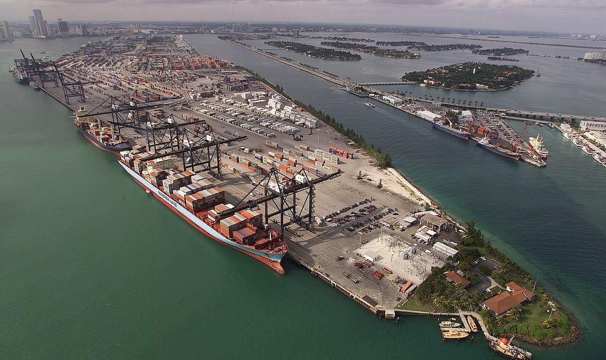 Aerial view of a container port with stacked shipping containers and cranes