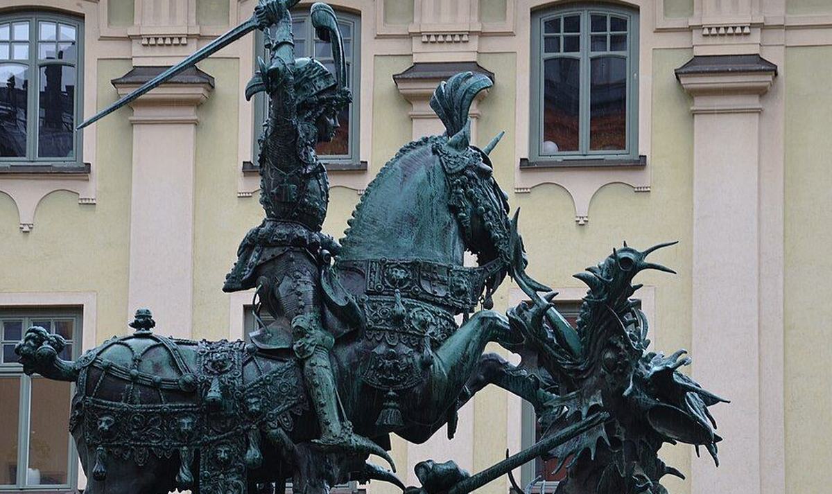 Bronze sculpture of an armoured knight on horseback fighting a dragon
